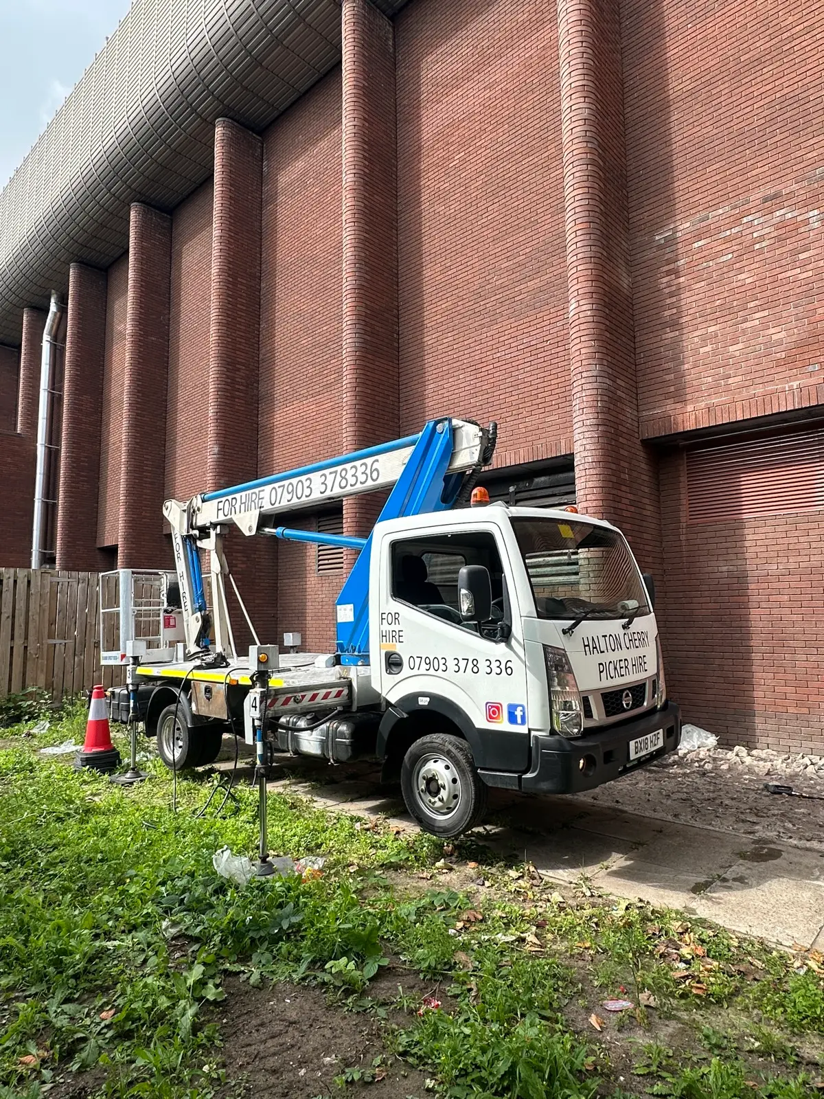 Halton Cherry Picker Hire vehicle set up outside a large commercial building